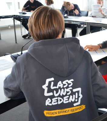 Logo der Respekt Coaches abgebildet auf der Rückseite eines Hoodies, der von einer Frau getragen wird.