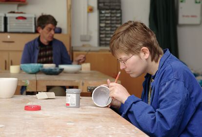 Zwei Personen arbeiten an Tassen und Schalen in der Werkstatt