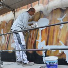 Maler verschließt die Risse in der Gebäudewand mit einem Spachtel