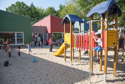 Außenspielbereich: spielende Kinder auf Kletterturm und im Sandkasten