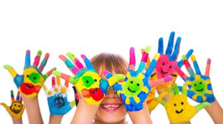 bunte Kinderhände vor einem Kindergesicht