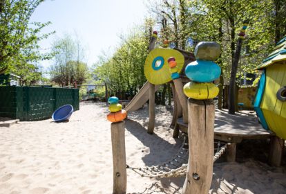 Außenspielbereich mitKletterturm aus Holz und Sandkasten